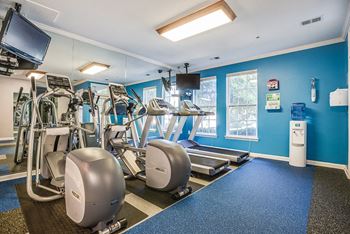 a gym with treadmills and other exercise equipment and a tv at The Residences at King Farm, Maryland, 20850